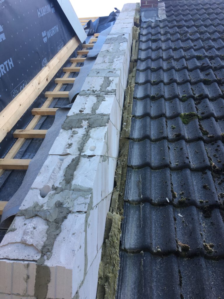 Vor Wettereinflüssen ungeschützter Spalt zwischen Neubau und Nachbarhaus.